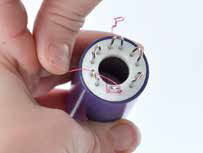 Wire being wrapped around the spokes of the knitter
